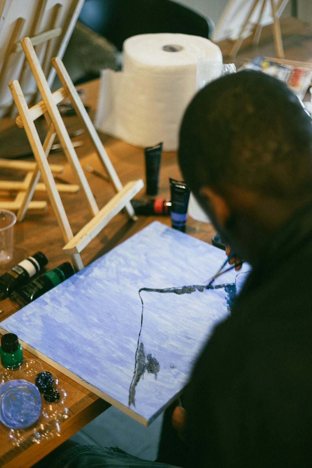 Seniors painting on canvases in a creative art workshop